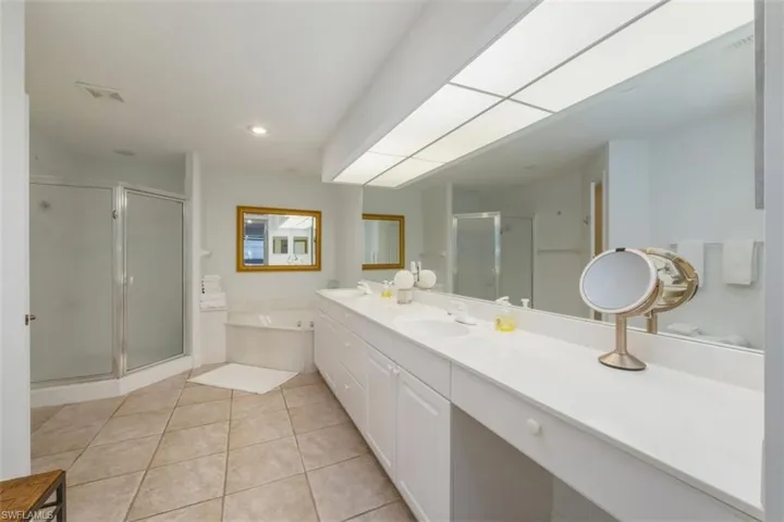 Full bathroom with a bath, light tile patterned floors, a stall shower, double vanity, and recessed lighting