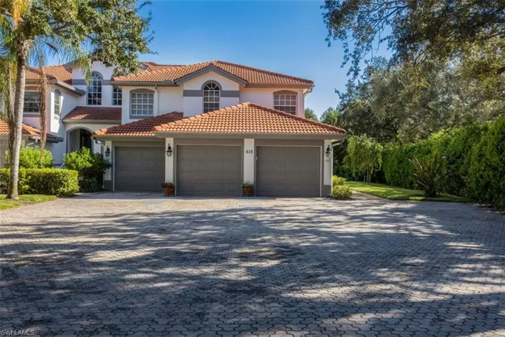Mediterranean / spanish home featuring decorative driveway, a tiled roof, stucco siding, and an attached garage