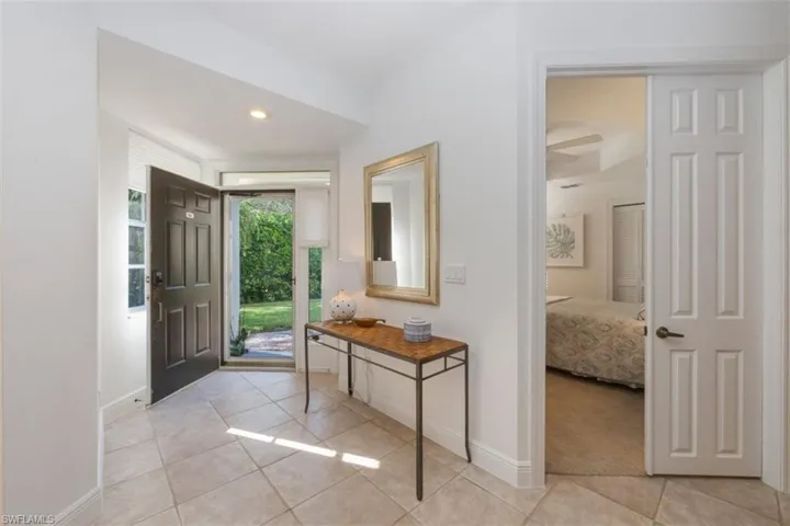 Entryway with light tile patterned floors and recessed lighting