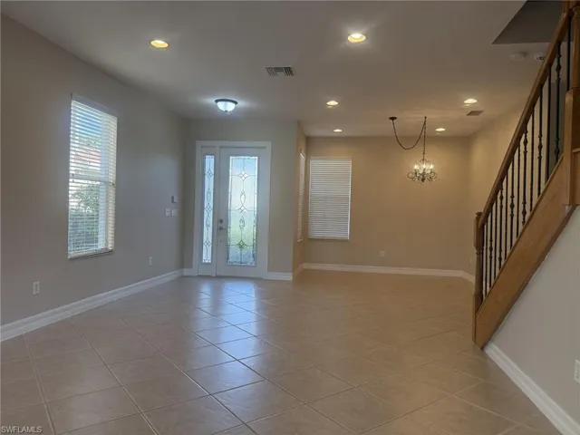 Entrance foyer with visible vents, baseboards, a chandelier, stairway, and recessed lighting