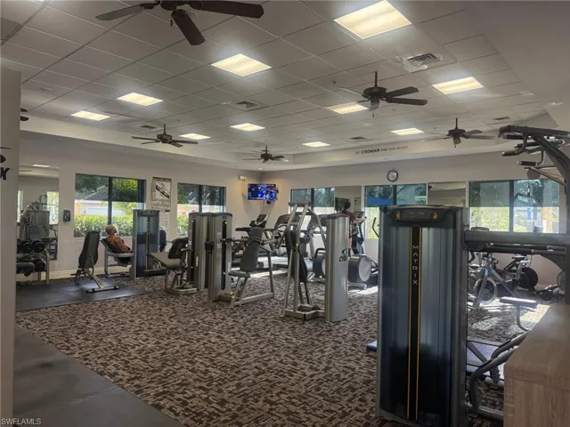 Exercise room featuring a paneled ceiling, visible vents, and ceiling fan