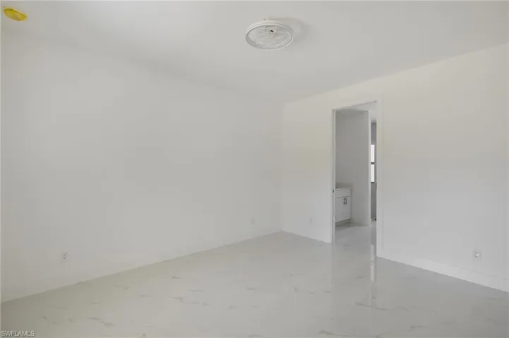Spare room with light marble finish floors and baseboards