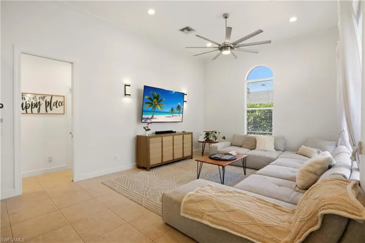 Living area featuring tile patterned flooring, recessed lighting, and a ceiling fan