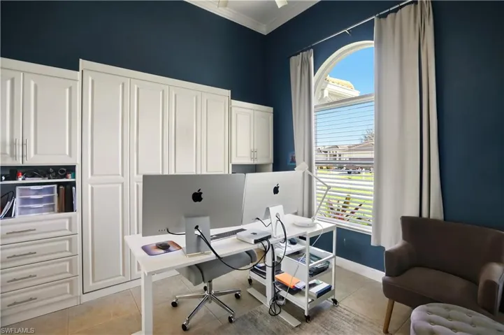 Office area with light tile patterned flooring and ornamental molding