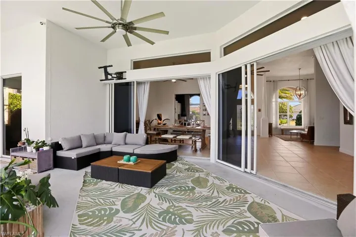 Living area featuring a chandelier, ceiling fan, and a high ceiling