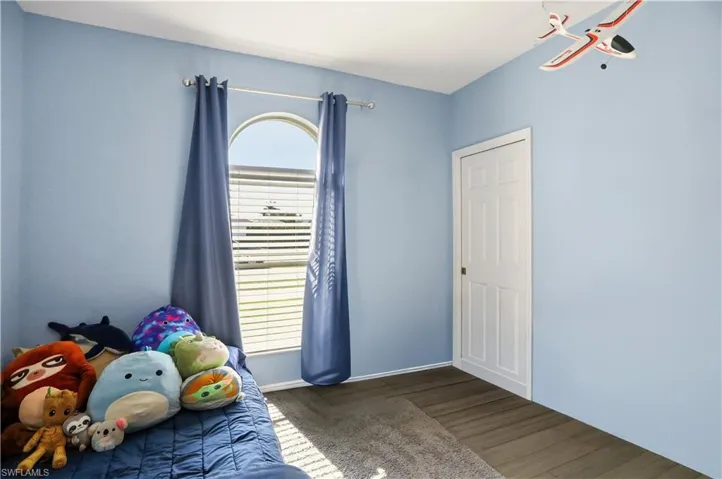 Unfurnished bedroom with wood finished floors and baseboards