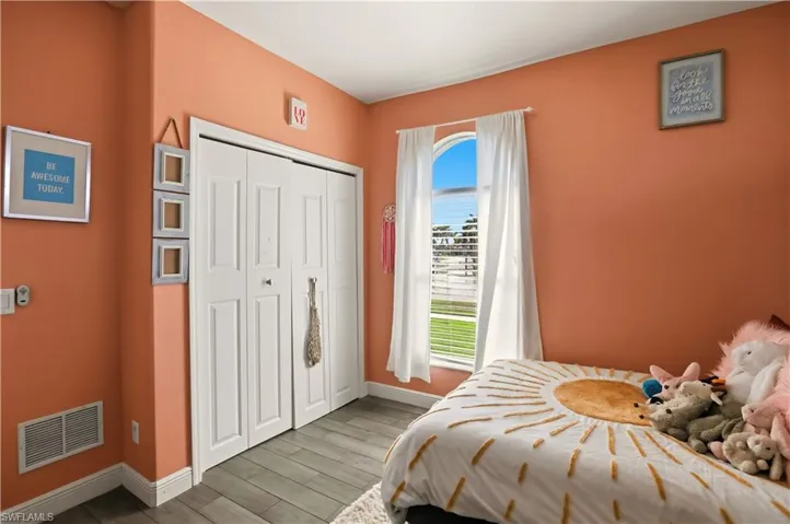 Bedroom featuring wood finish floors and a closet