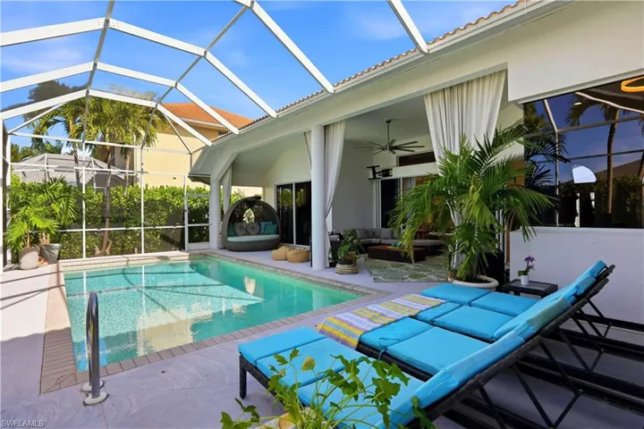 Swimming pool with a sunroom, an outdoor living space, a patio, and glass enclosure