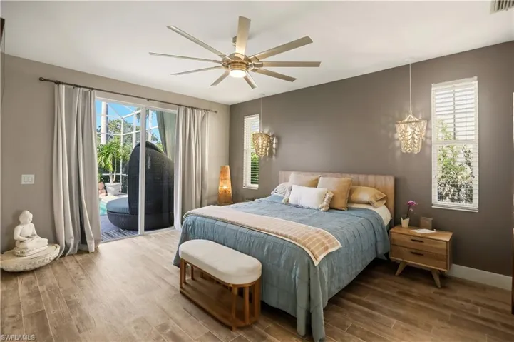 Bedroom with wood finished floors, access to exterior, and a ceiling fan