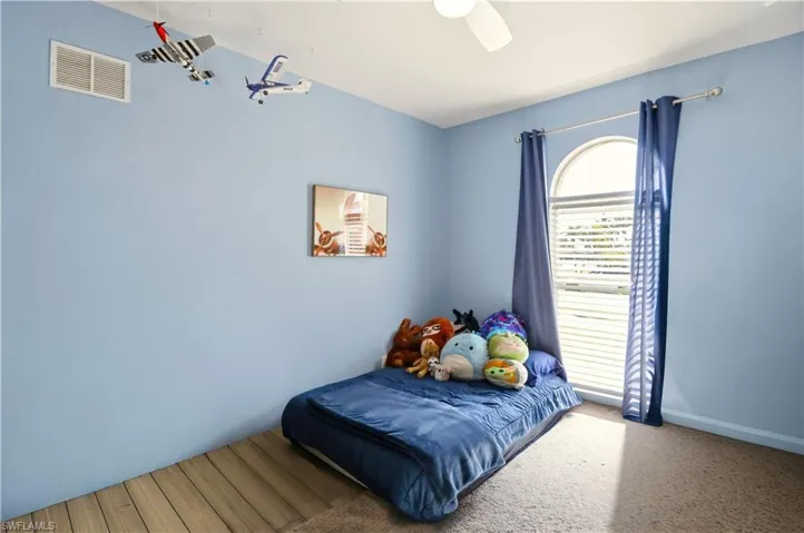 Bedroom featuring ceiling fan and carpet floors