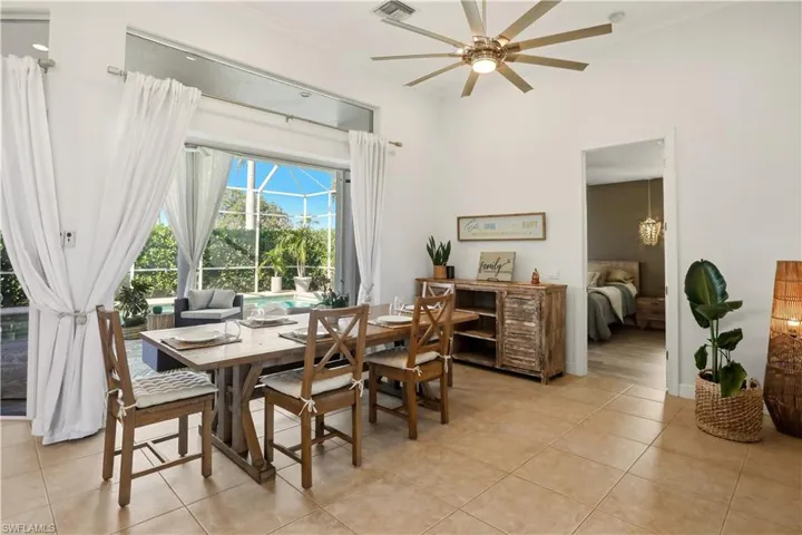 Dining room with a ceiling fan, a sunroom, light tile patterned floors, and crown molding