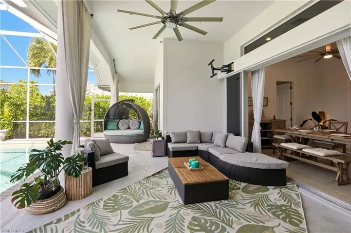 View of patio / terrace featuring a ceiling fan, glass enclosure, a sunroom, outdoor lounge area, and an outdoor pool
