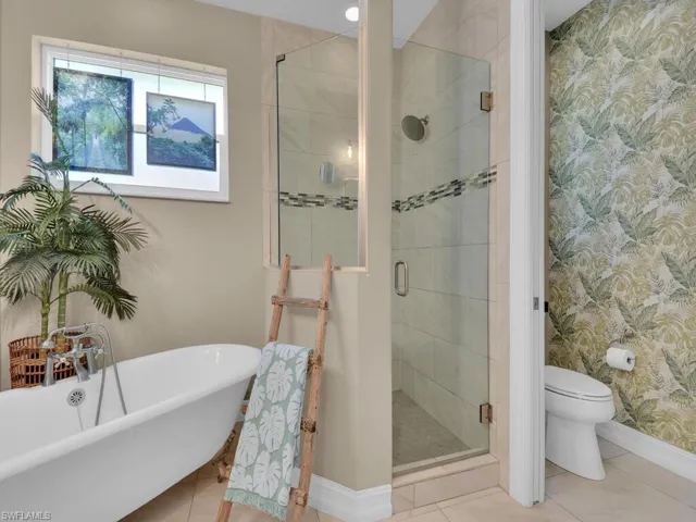 Bathroom with tile patterned flooring, toilet, and shower with separate bathtub