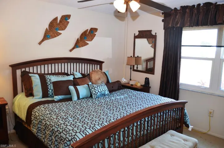 Carpeted bedroom featuring baseboards and a ceiling fan