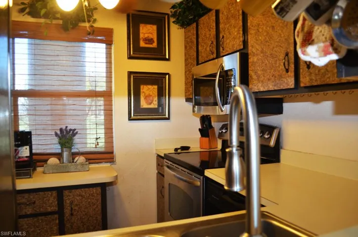 Kitchen featuring stainless steel microwave and light countertops