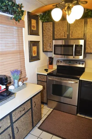 Kitchen with appliances with stainless steel finishes, light countertops, and light tile patterned floors