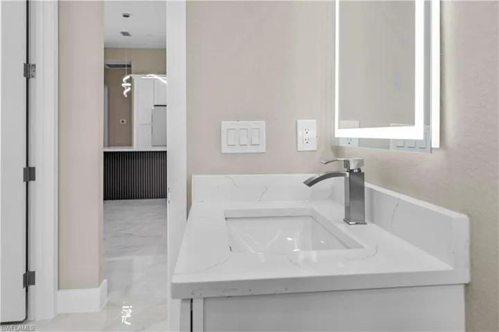 Bathroom with vanity and a textured wall