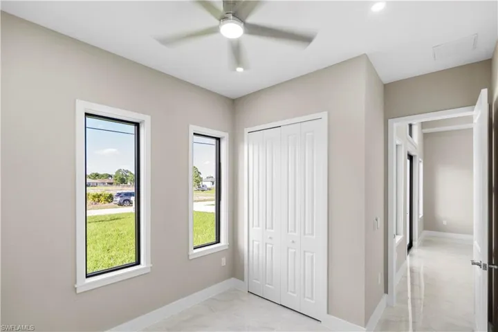 Unfurnished bedroom with a closet, light marble finish flooring, a ceiling fan, and recessed lighting