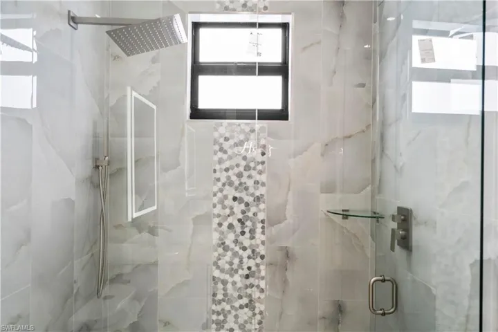 Full bath featuring a marble finish shower