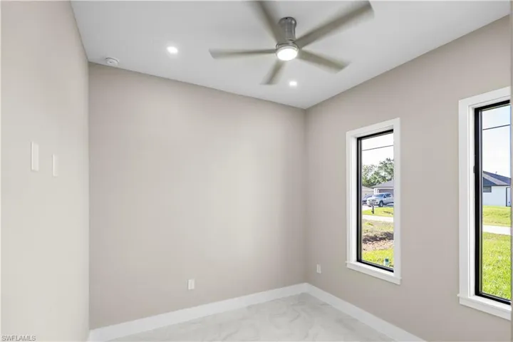 Empty room featuring light marble finish floors, recessed lighting, and a ceiling fan
