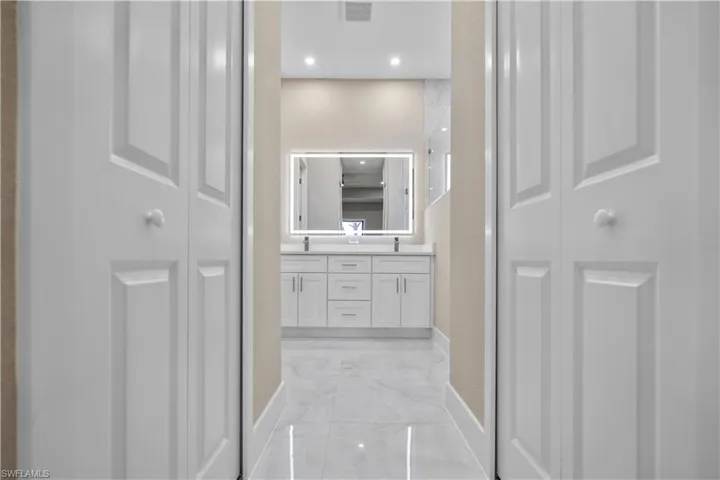 Master Full bathroom featuring a closet, double vanity, light marble finish flooring, and recessed lighting