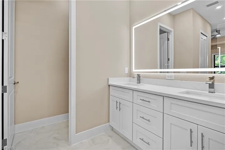 Master Bathroom with double vanity and light marble finish flooring
