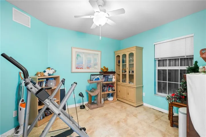 Workout room featuring a ceiling fan and baseboards