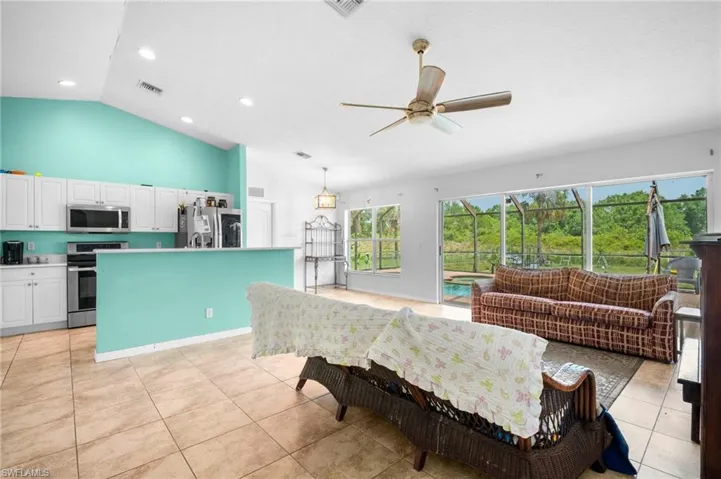 Living area featuring a ceiling fan, light tile patterned floors, recessed lighting, and high vaulted ceiling