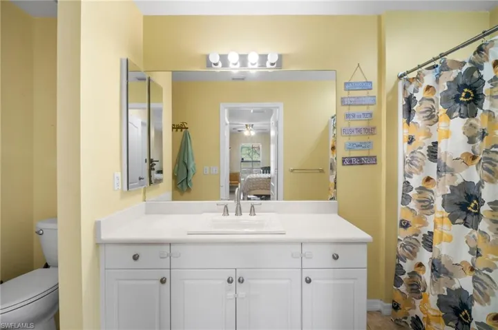Ensuite bathroom with vanity, toilet, and a shower with curtain