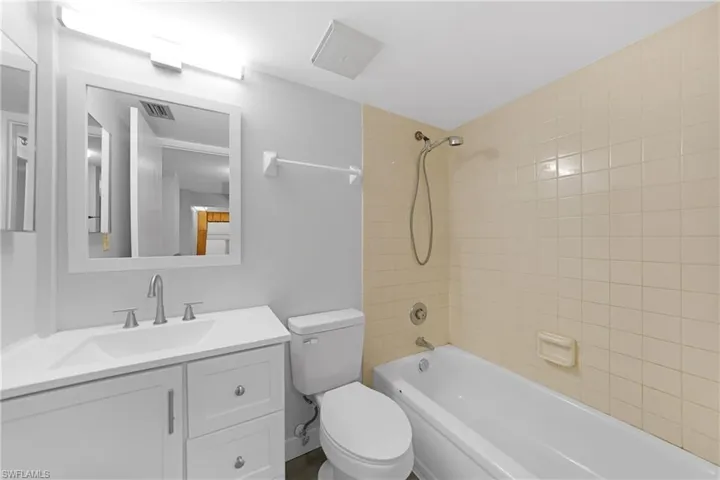 Full bathroom featuring toilet, tiled shower / bath, and vanity