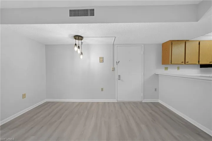 Unfurnished dining area featuring a textured ceiling and light hardwood / wood-style flooring