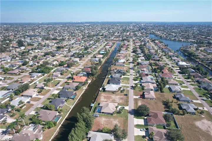 Aerial view of property and surrounding area with nearby suburban area and a nearby body of water