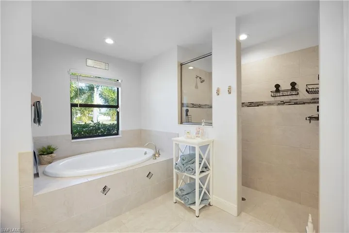 Bathroom with a garden tub, a walk in shower, tile patterned flooring, and recessed lighting