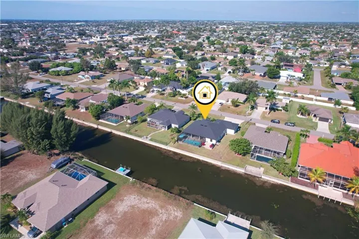 Aerial view of property and surrounding area with nearby suburban area and a large body of water