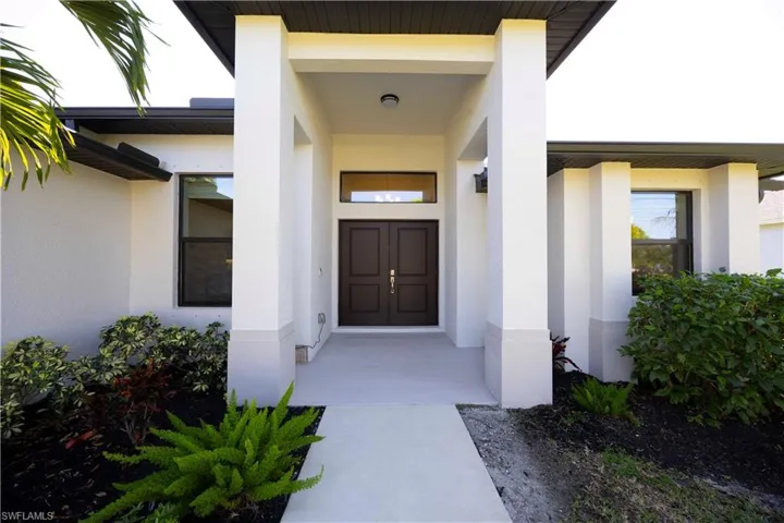 View of exterior entry featuring stucco siding and a porch