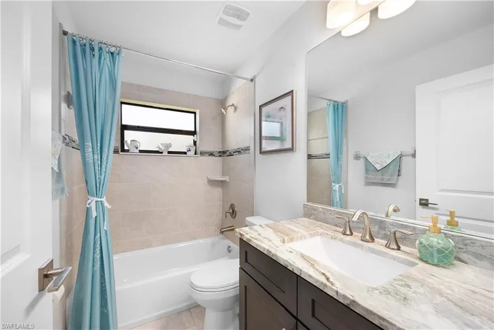 Full bathroom featuring shower / bath combo with shower curtain and vanity