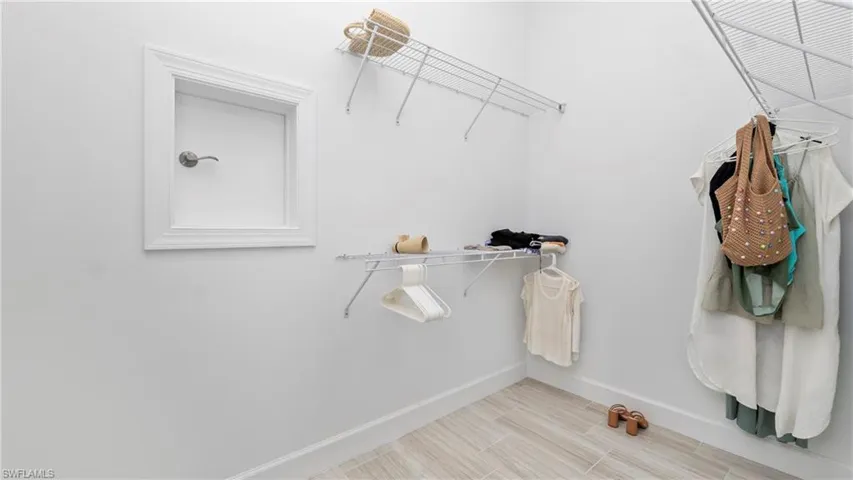 Walk-in Primary Bedroom Closet with easy access door to Laundry Room