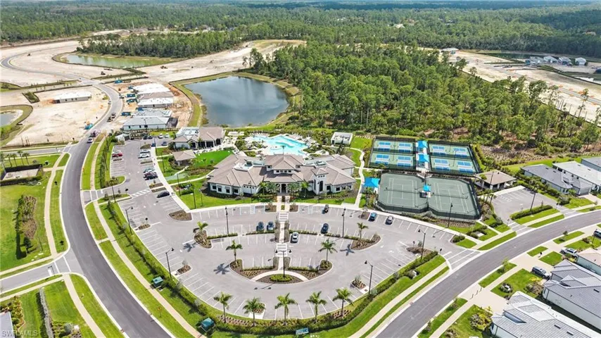 Aerial view of property's location featuring a forest and a large body of water
