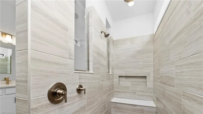 Bathroom with vanity and a tile shower
