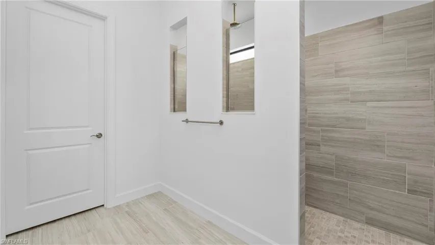 Bathroom featuring walk in shower and baseboards