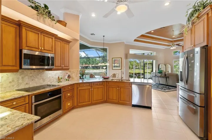 Kitchen with a sink, stainless steel appliances, a peninsula, and brown cabinetry