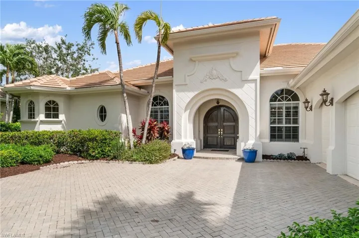 Doorway to property with stucco siding, an attached garage, and a tiled roof