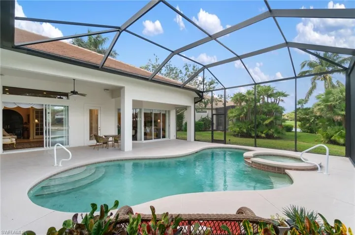 View of swimming pool with a pool with connected hot tub, glass enclosure, ceiling fan, and a patio