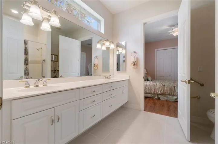 Bathroom featuring a shower stall, tile patterned floors, double vanity, and a sink