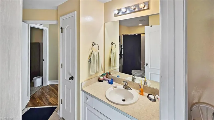 Bathroom with toilet, wood finished floors, and vanity