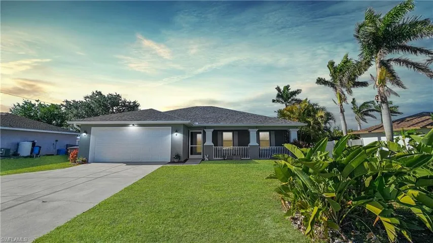 Ranch-style home with driveway, a porch, a yard, stucco siding, and a garage