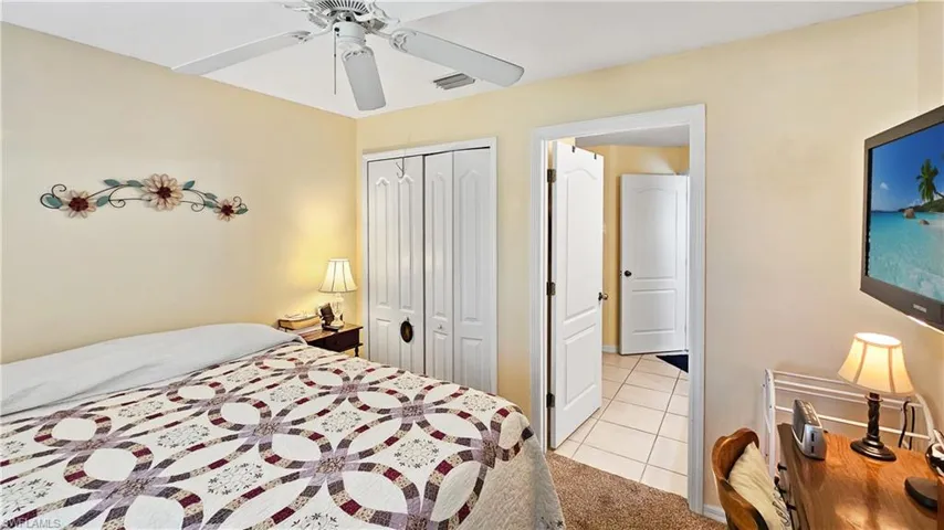 Bedroom with a closet, visible vents, ceiling fan, and light tile patterned flooring