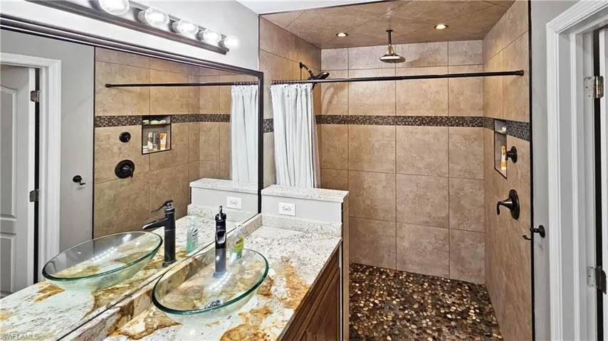 Bathroom with a tile shower and vanity