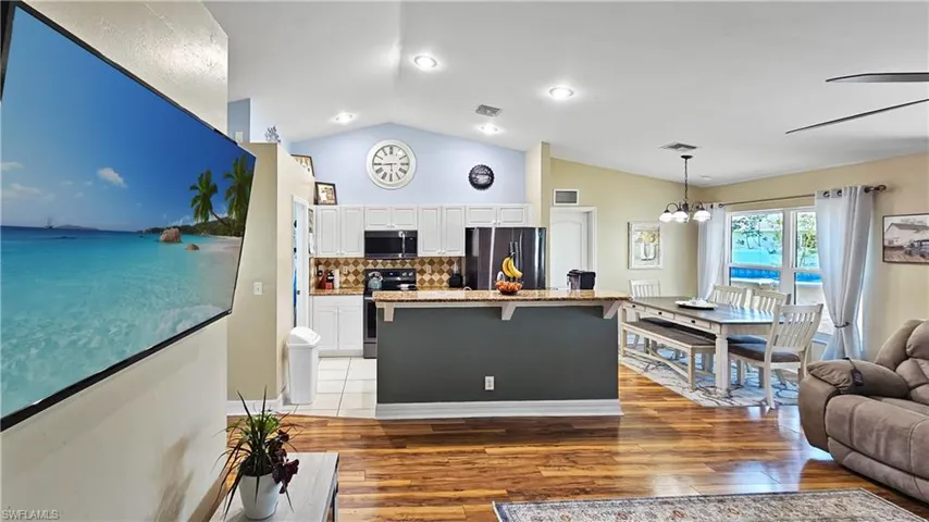 Kitchen featuring visible vents, a breakfast bar, appliances with stainless steel finishes, white cabinetry, and a chandelier