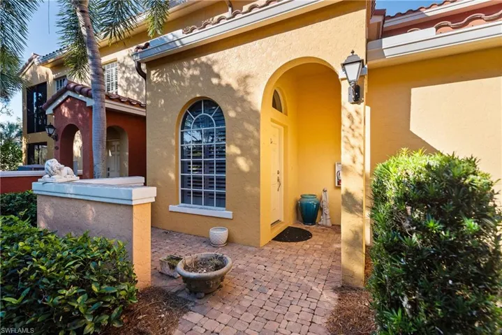 Entrance to property with a patio, a tiled roof, and stucco siding